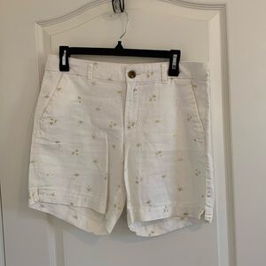 ON white linen shorts with gold palm trees.